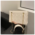 Detail van de crèmekleurige crossbodytas met zigzag-stikselpatroon en gouden ketting - Wit