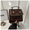 Vue détaillée du sac à dos rétro marron foncé en similicuir avec rivets dorés et bouton pression - café