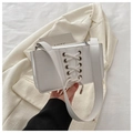 Detailed view of white faux leather crossbody bag with stylish lace-up metal eyelet design - White