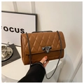 Detailed view of brown quilted crossbody bag with metal chain strap and twist lock closure - Brown