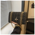 Dettaglio della trama in tweed nero e oro con catena metallica su una borsa a tracolla - Nero