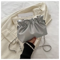 Detalle de bolso nube plateado con cadena metálica sobre una americana beige - Plateado