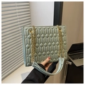Mint green quilted crossbody square bag with gold chain strap held by hand - Green