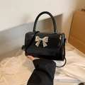 Schwarze Lackleder-Umhängetasche mit silberner Schleife und elegantem Tragegriff - Schwarz