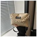 Detailansicht der cremefarbenen PU-Tasche mit dicker weißer Kette und Modeaufkleber - Khaki
