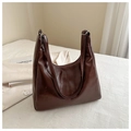 Close-up of a soft dark brown hobo shoulder bag with a glossy finish and metal buckles - Coffee