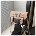 Detalle de bolso bandolera con decoración de lazo metálico y colores contrastados - Rosa y Negro