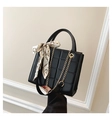 Détail d'un sac noir matelassé avec poignée foulard en soie et bandoulière dorée - Noir