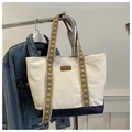Detail of canvas tote bag with contrast base and geometric patterned woven handles - Blue