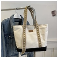 Detailed view of bicolor canvas tote bag featuring geometric pattern woven straps - Black