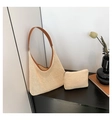 Détail d'un ensemble de sacs tissés crème avec anses en cuir marron sur fond minimaliste - Marron