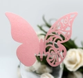 Detail of pink laser-cut butterfly card with hollow vine texture on a glass rim - Pink