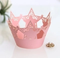 Detail of pink pearlescent laser-cut cupcake wrapper with star patterns and crown edges - Pink