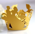 Macro view of golden laser-cut cupcake wrappers with heart and wedding couple motifs - Gold