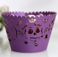 Close-up of purple laser-cut cupcake wrapper with skull and star patterns for Halloween - Dark Purple