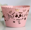 Detailed close-up of pink laser-cut cupcake wrappers with skull and star patterns - Pink