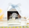 Nahaufnahme des hohlen Blumenmusters auf silberner Geschenkbox mit blauer Schleife - Reflektierendes Silber