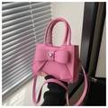 Detail der rosa Schleifenhandtasche mit Herz-Strass-Akzent und Tragegriff - Fuchsia