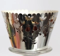Close-up of silver hollow cupcake wrapper with skull and floral cutout patterns - Reflective Silver