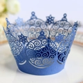 Blue laser-cut cupcake wrappers with snowflake crown design on a white ceramic plate - Sapphire Blue