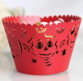 Macro detail of red laser-cut cupcake wrapper with intricate sugar skull and floral patterns - Pearlescent Red