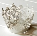 Detail of white laser-cut cupcake wrappers with Christmas ball and star hollow patterns - Silver