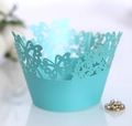 Macro detail of sky blue laser-cut cupcake wrappers with butterfly and flower patterns - 5cm / Tiffany Blue