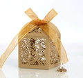 Detail einer lasergeschnittenen goldenen Geschenkbox mit Spitzenmuster und Seidenband - Beige Gold