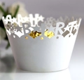 Macro shot of laser-cut Happy Birthday white paper cupcake wrapper with gold foil lining - White