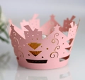 Macro shot of laser-cut pink Christmas tree patterns on a delicate cupcake wrapper - Pink