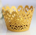 Close-up of golden laser-cut cupcake wrappers with intricate crown vine hollow patterns - 5cm / Gold