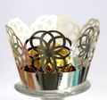 Makro-Detail der silbernen lasergeschnittenen Cupcake-Hülle mit floralem Lochmuster - Reflektierendes Silber