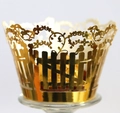 Macro detail of gold laser-cut cupcake wrappers with bird and fence pattern - Reflective Gold