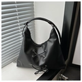 Detail of a black hobo bag with a lace-up decorative bow and silver metal eyelets - Black