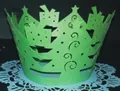 Detail of green laser-cut Christmas tree cupcake wrapper with festive hollow patterns - Dark Green