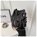 Detail of a black sequined bucket bag with a silver chain strap and drawstring closure - Black