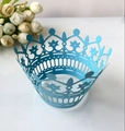 Detail of light blue crown laser-cut cupcake wrappers on a white reflective surface - Sky Blue