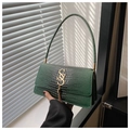 Detail of dark green crocodile texture handbag with gold SS logo and tassel pendant - Green