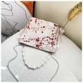 Close-up of pink jacquard bucket bag with floral embroidery and pearl handle strap - Red