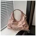 Detalle de un bolso tote rosa claro con lazos decorativos y asa superior elegante - Rosa