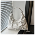 Detalle del bolso tote blanco con pliegues verticales y un lazo decorativo en cuero suave - Blanco