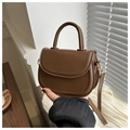 Detalle de mini bolso montura marrón oscuro con textura de cuero fino y ganchos de metal - Marrón