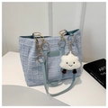 Dettaglio della borsa in maglia azzurra con manici in pelle e ciondolo nuvola bianca - Blu (Con Ciondolo)
