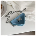 Close-up of blue triangle mini bag with silver butterfly charm and metal chain strap - Blue