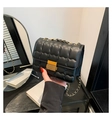 Detalle de bolso acolchado negro con cadena, broche dorado y textura de cuero sintético - Negro
