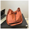 Macro shot of brick red nylon bucket bag showing drawstring closure and side buckle detail - Orange Without Pendant