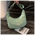 Detailed view of light green waterproof nylon dumpling bag with adjustable strap - Green