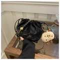 Detail of black drawstring bucket bag with gold chain strap and cute plush biscuit charm - Black With Pendant
