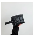 Detail of black quilted tote bag showing padded fabric texture and puffy handle design - Black