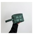 Detail of dark green quilted padded handbag with glossy finish and soft fabric texture - Green